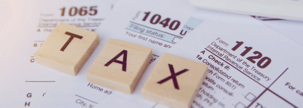 Tax season with wooden alphabet blocks, calculator, pen on 1040 tax form